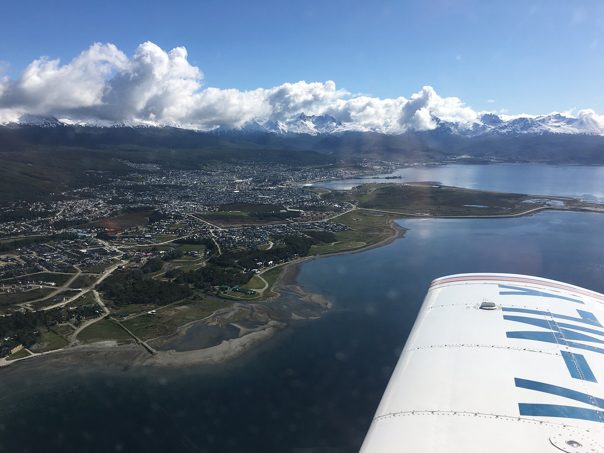 Ushuaia desde una avioneta, con el ala en primer plano