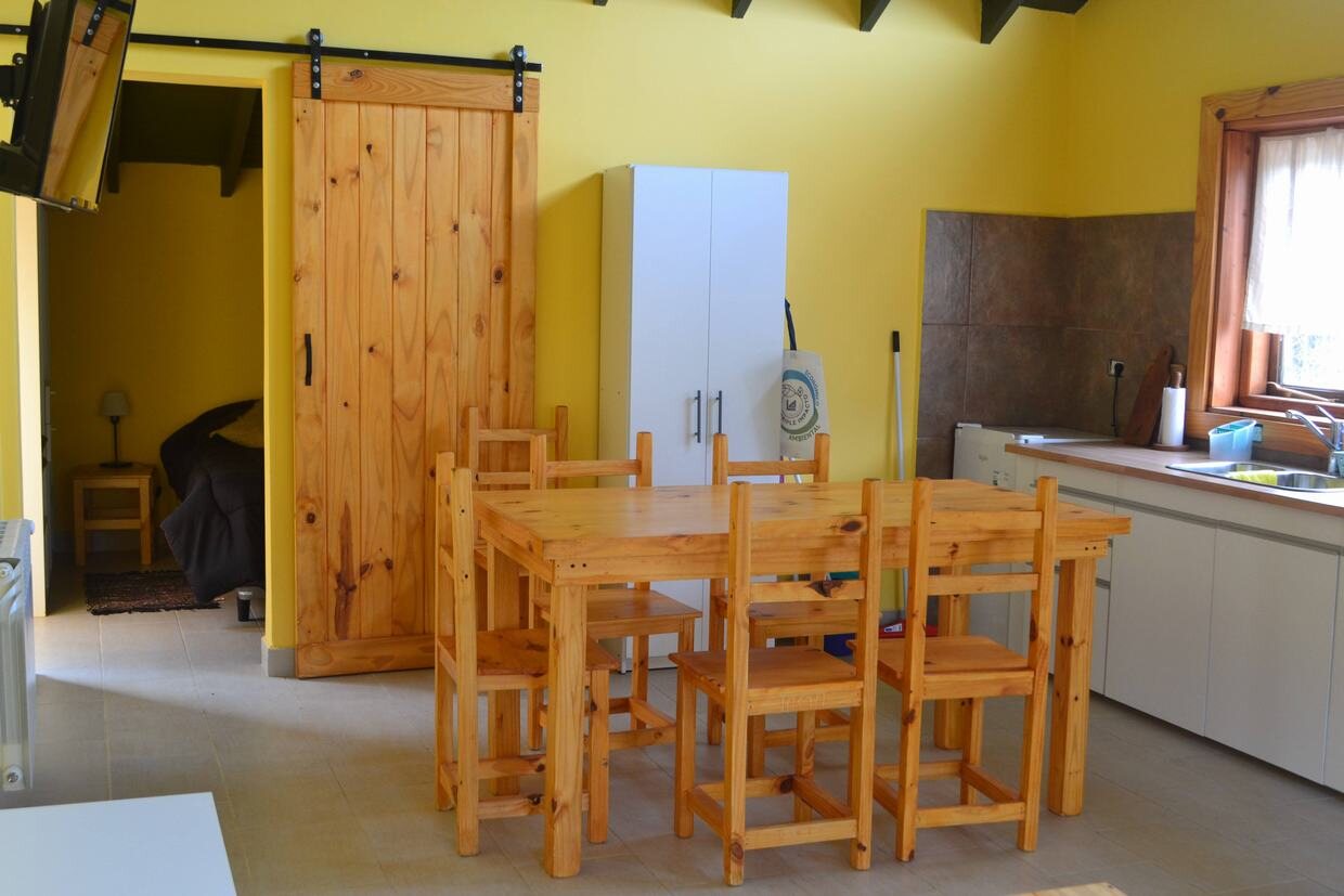 Mesa de madera con sillas junto a la cocina