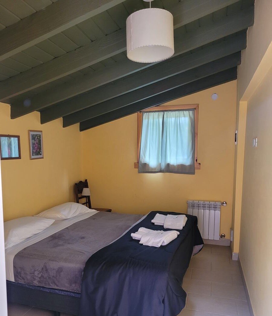 Dormitorio con cama de dos plazas y ventana