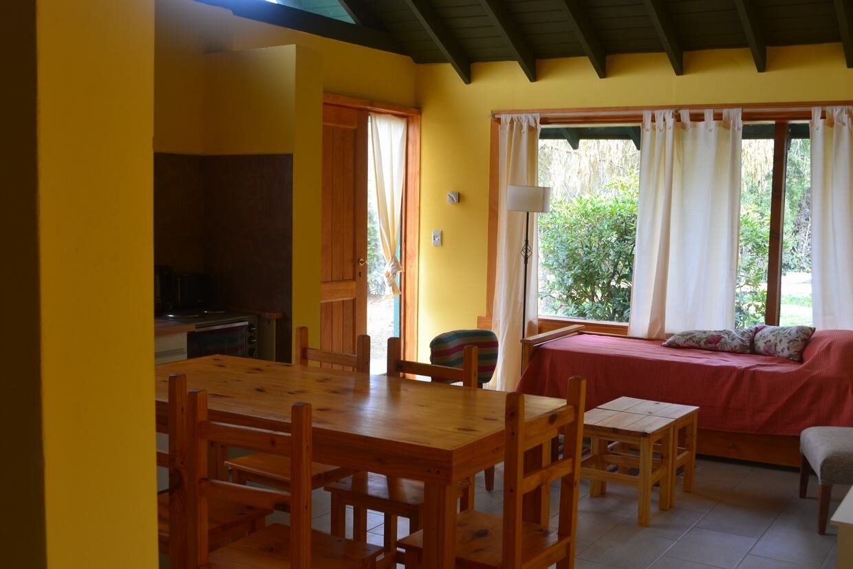 Cocina-comedor con mesa de madera y sofá