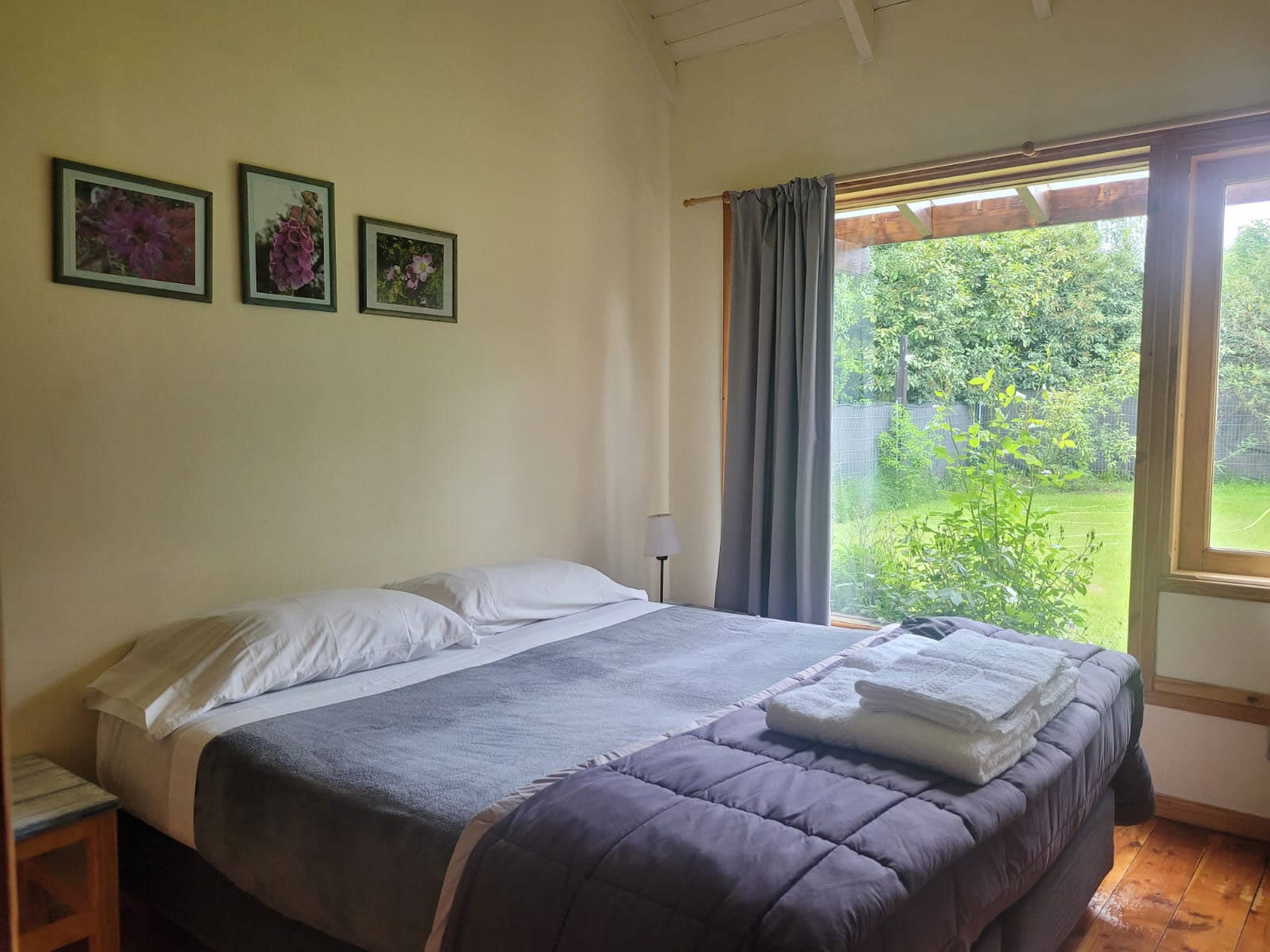 Dormitorio con cama de dos plazas y ventanal al parque