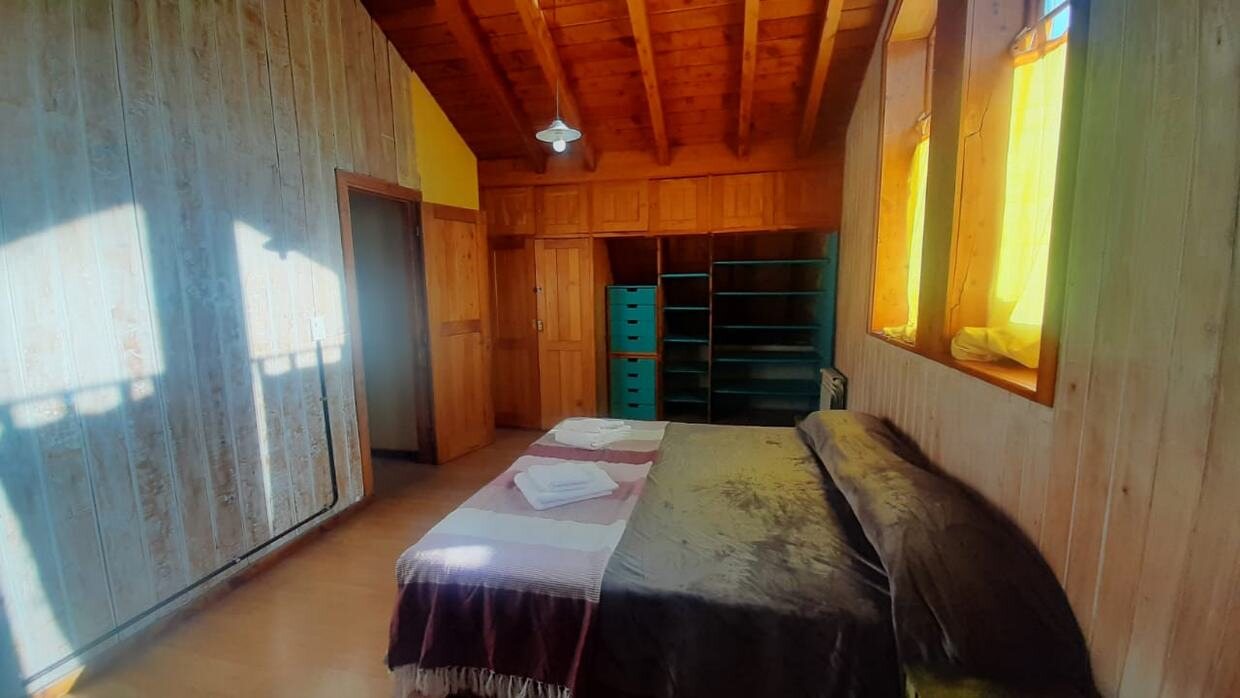 Dormitorio en planta alta con techo de madera