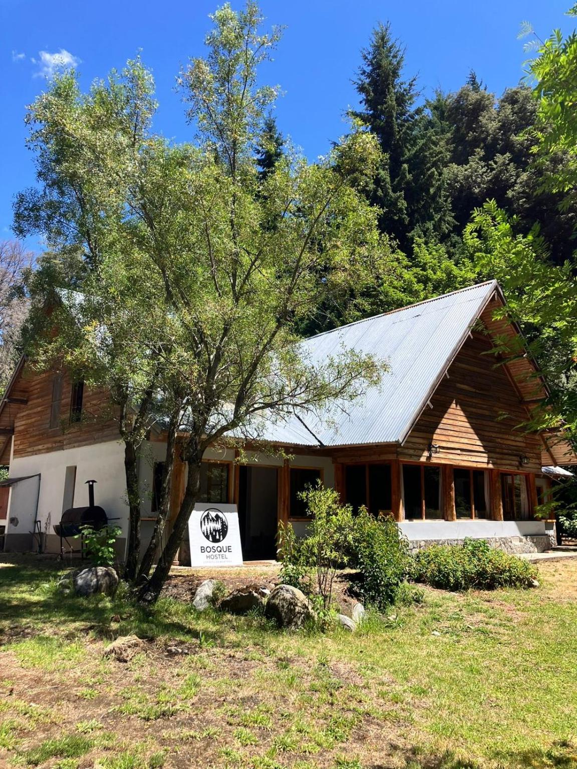 The Bosque Hostel house among the trees, in summer