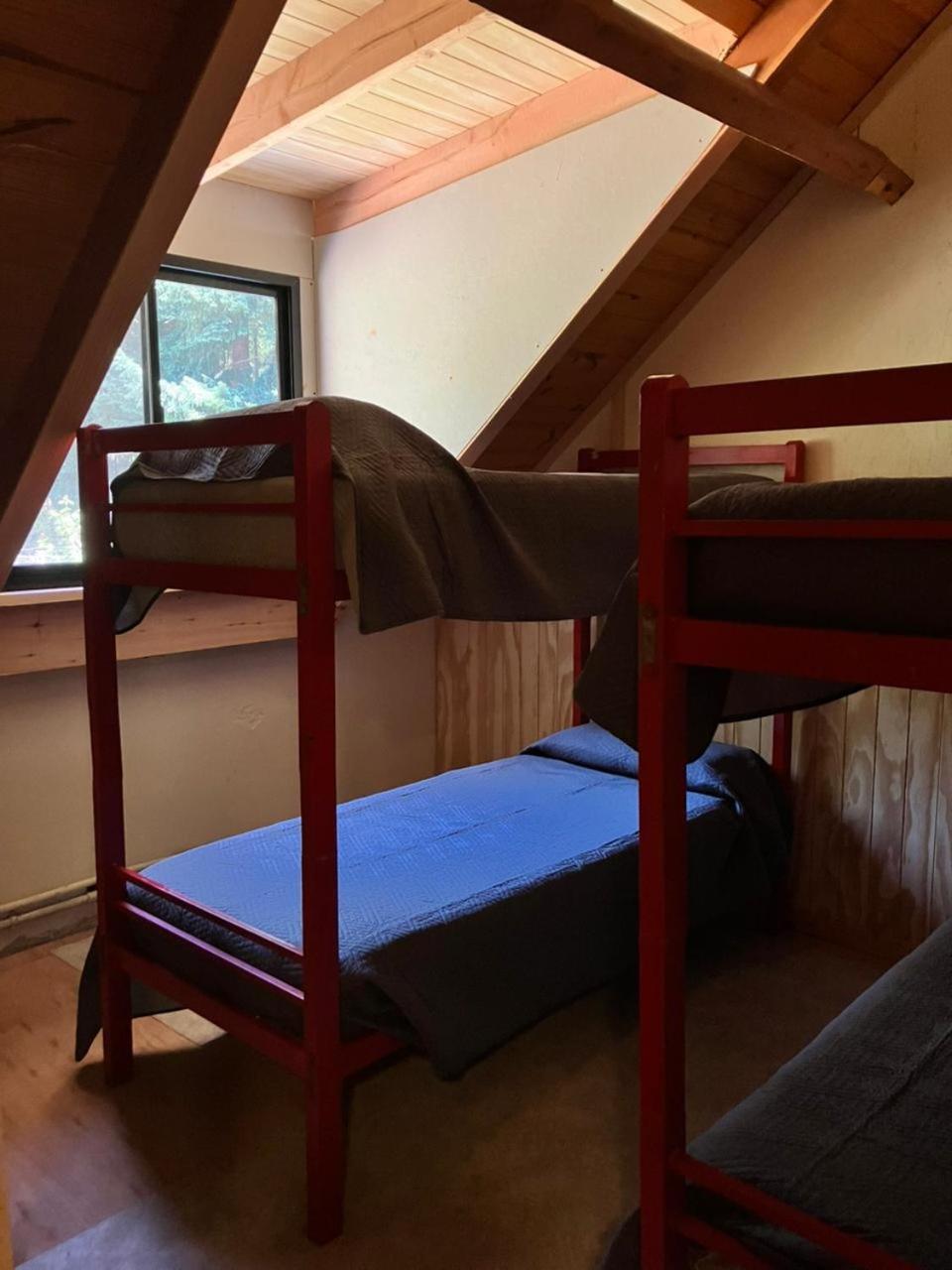 Red wooden bunk beds under the pitched roof