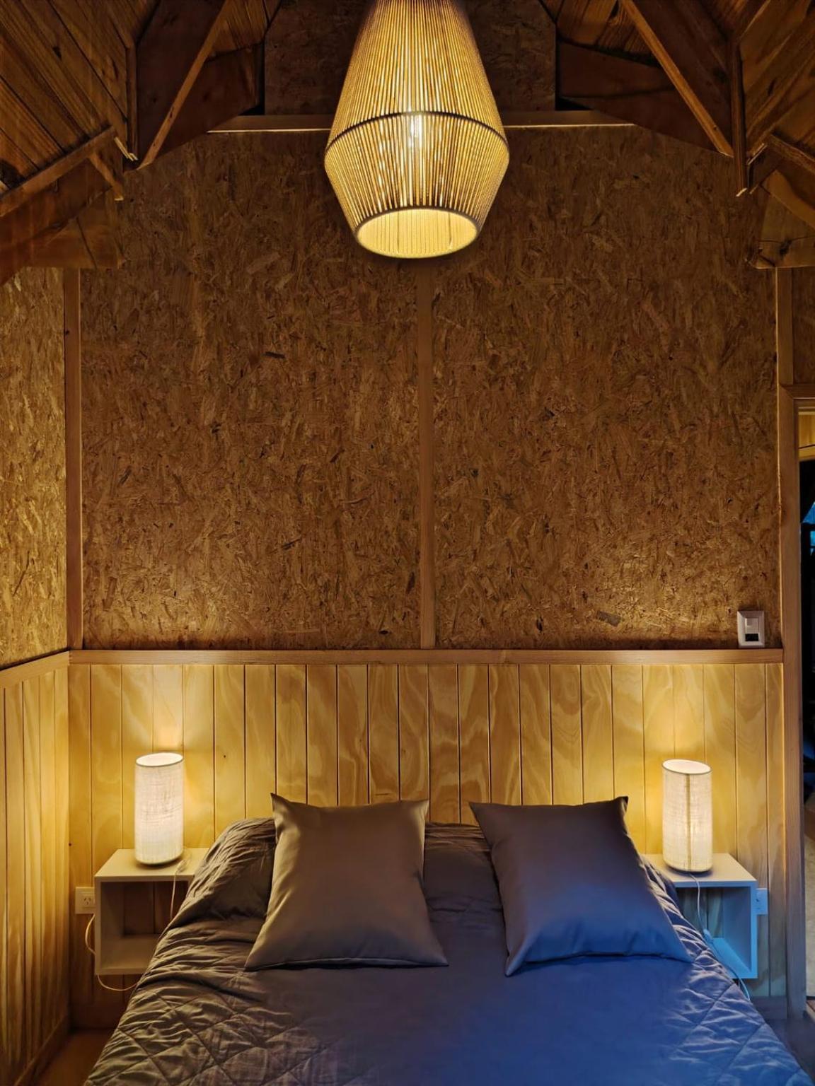 Double bed with a wicker lamp and bedside lights