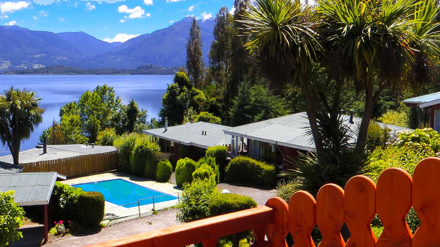 Piscina, cabañas y vista al lago Villarrica desde una terraza