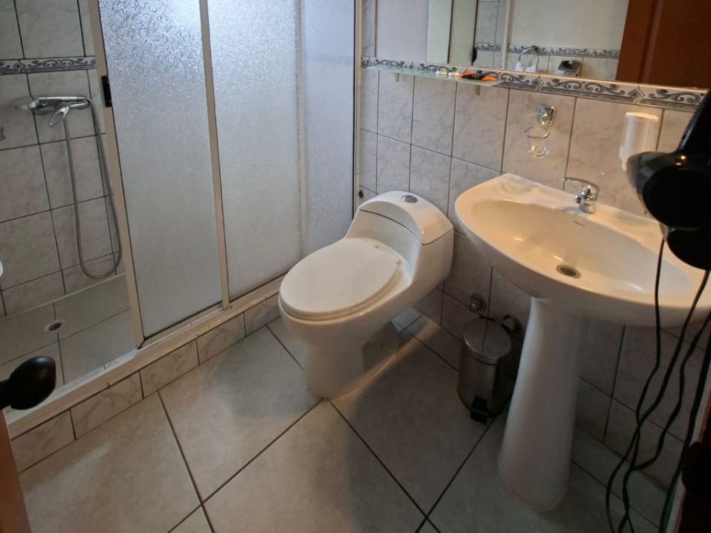 Baño privado con ducha, lavamanos y secador de pelo