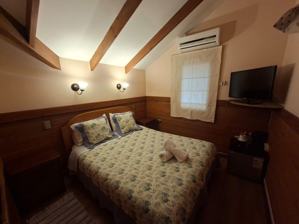 Habitación con dos camas, vigas de madera a la vista y mesa de té