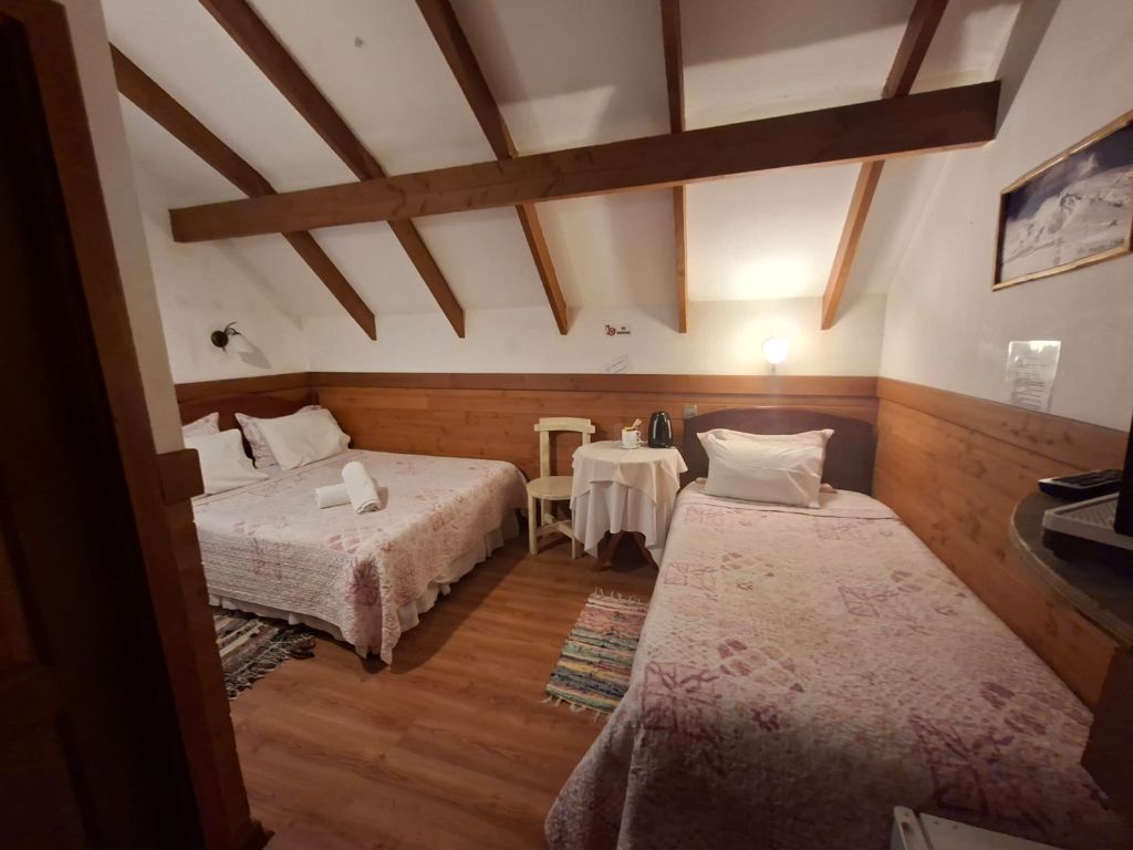 Habitación con dos camas individuales, cubrecamas florales y alfombra tejida