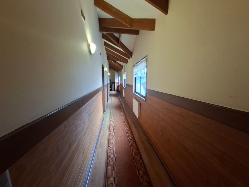 Pasillo interior con revestimiento de madera y vigas