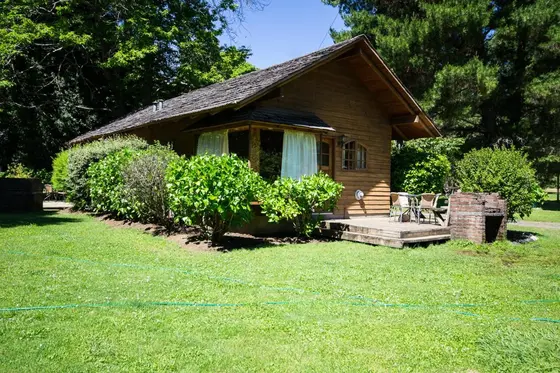 Cabaña de madera con terraza en un jardín de césped