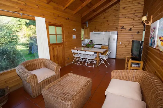 Living con sillones de mimbre, comedor y cocina