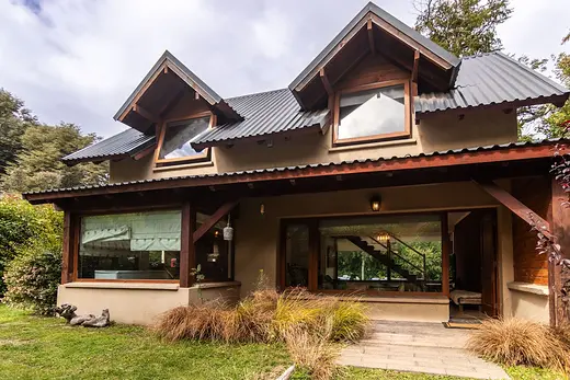 Frente de la casa con ventanales y galería