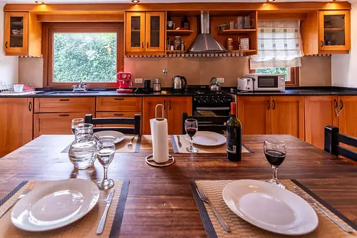 Cocina y comedor con mesa de madera