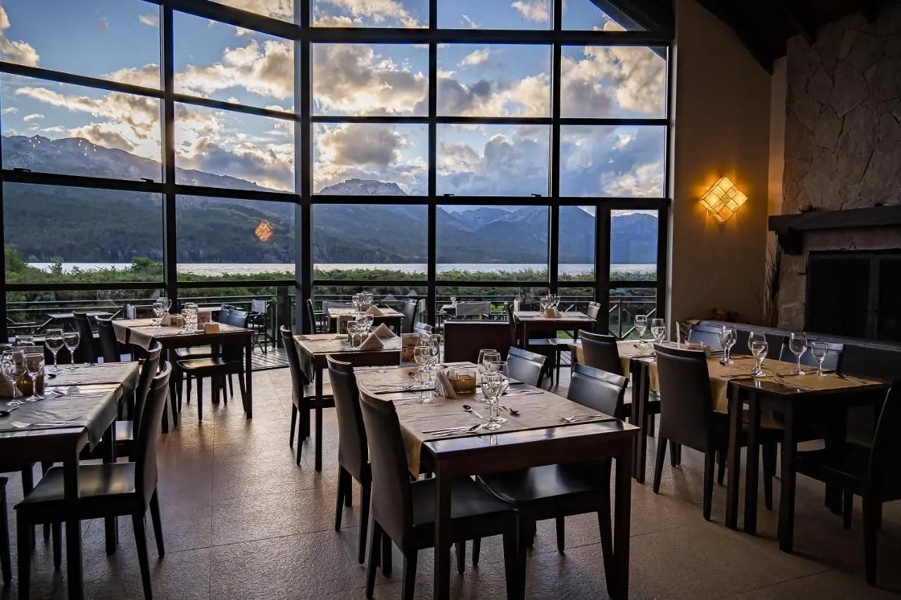 Salón del restaurante con ventanales al lago y a las montañas