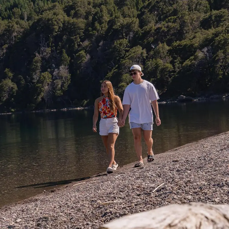 Pareja caminando por la orilla del lago