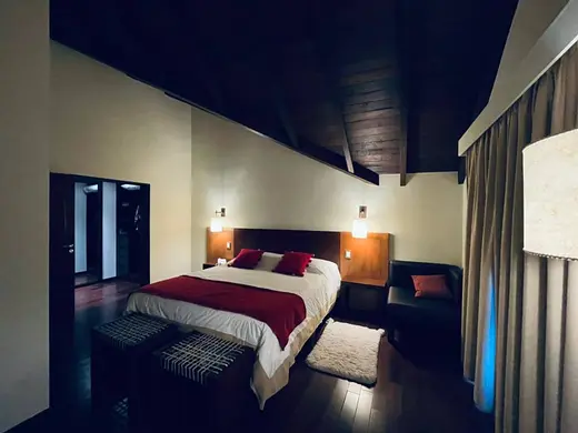 Habitación con cama matrimonial y sillón