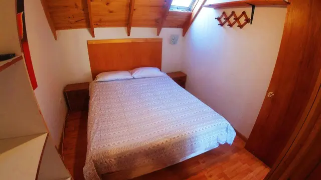 Dormitorio bajo el techo de madera