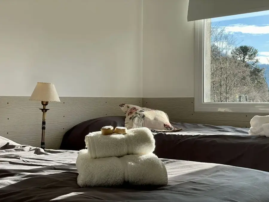 Dormitorio con sommier, ropa de cama y toallas