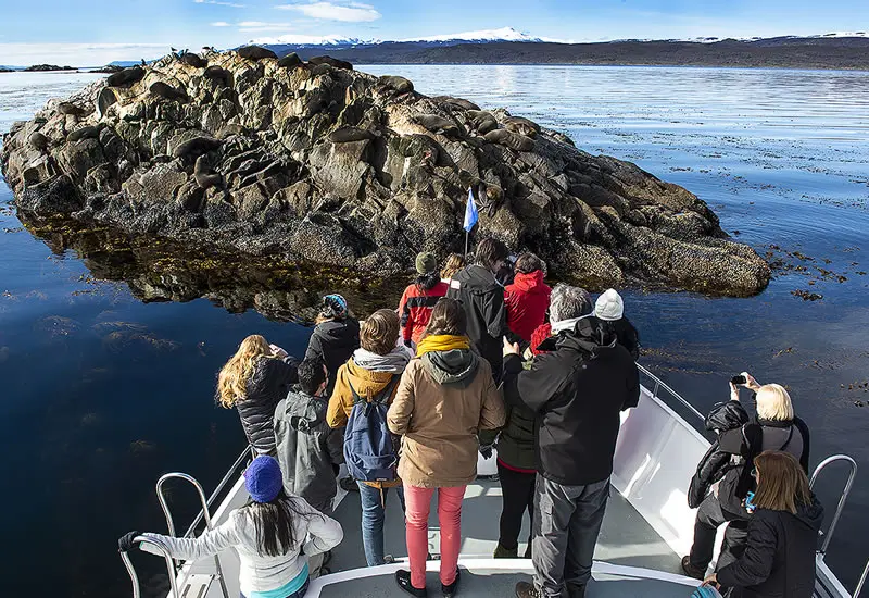Pasajeros en la proa, frente a una isla