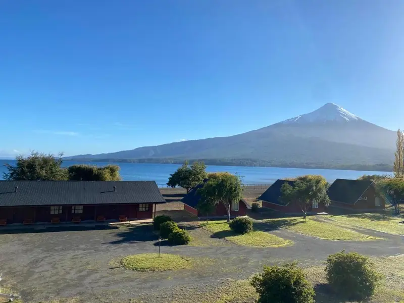 Las cabañas y el lago con el volcán