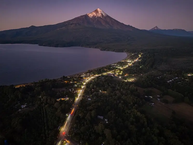 Vista aérea de Ensenada y el lago al anochecer, con el volcán Osorno