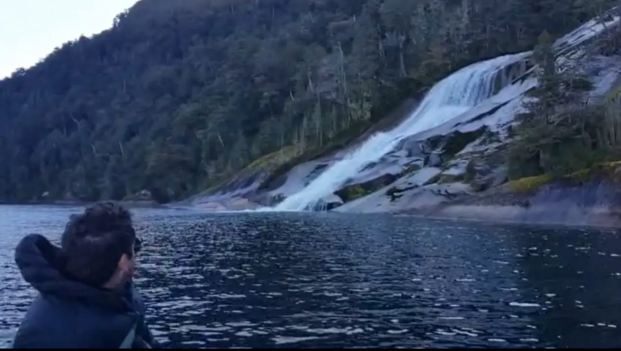 Mirando la cascada sobre el granito desde la embarcación