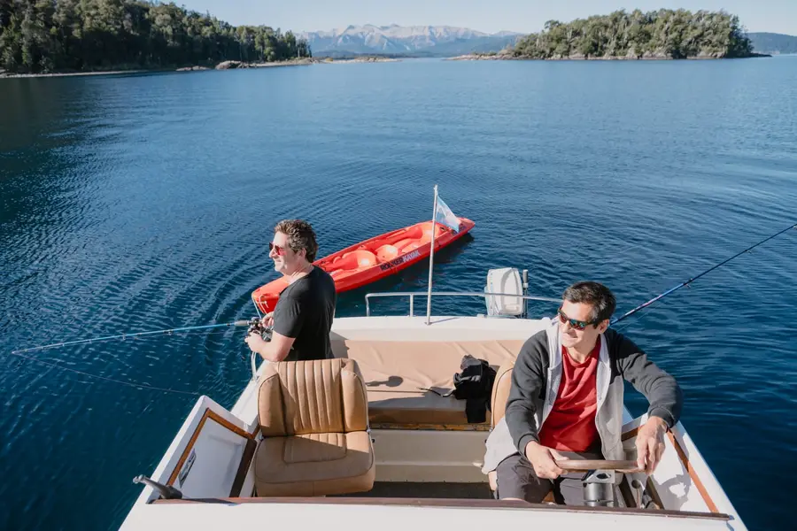 Walter y Sergio pescando desde la embarcación, con un kayak a remolque