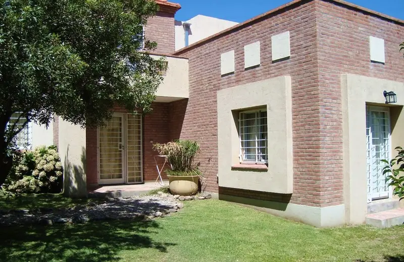 Cabaña de ladrillo visto, con su jardín