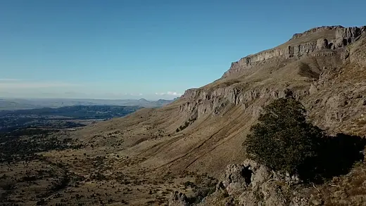 Vista aérea de una barda rocosa sobre el valle