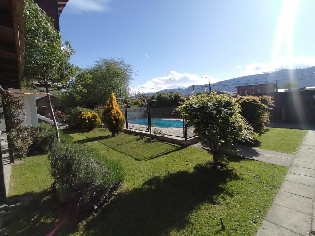 Jardín y pileta de Lugar de Descanso con las montañas al fondo