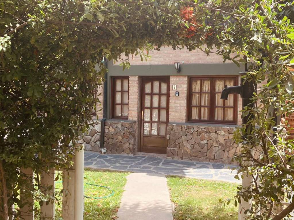 Entrada de una unidad bajo la enredadera · Lugar de Descanso, El Bolsón