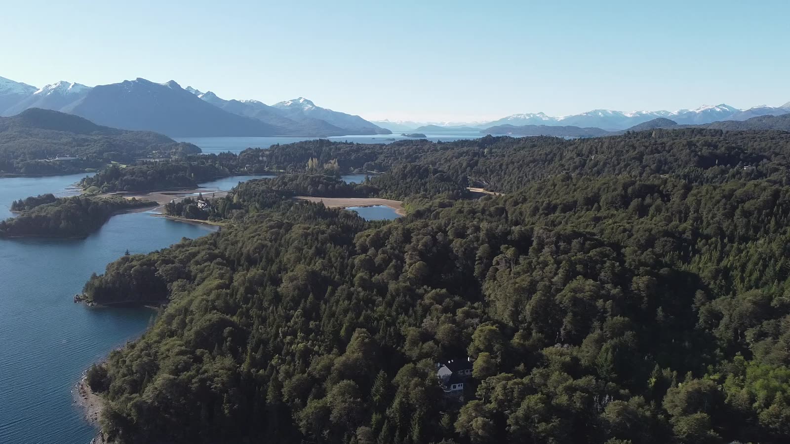Vista aérea del bosque, el lago y la cordillera nevada