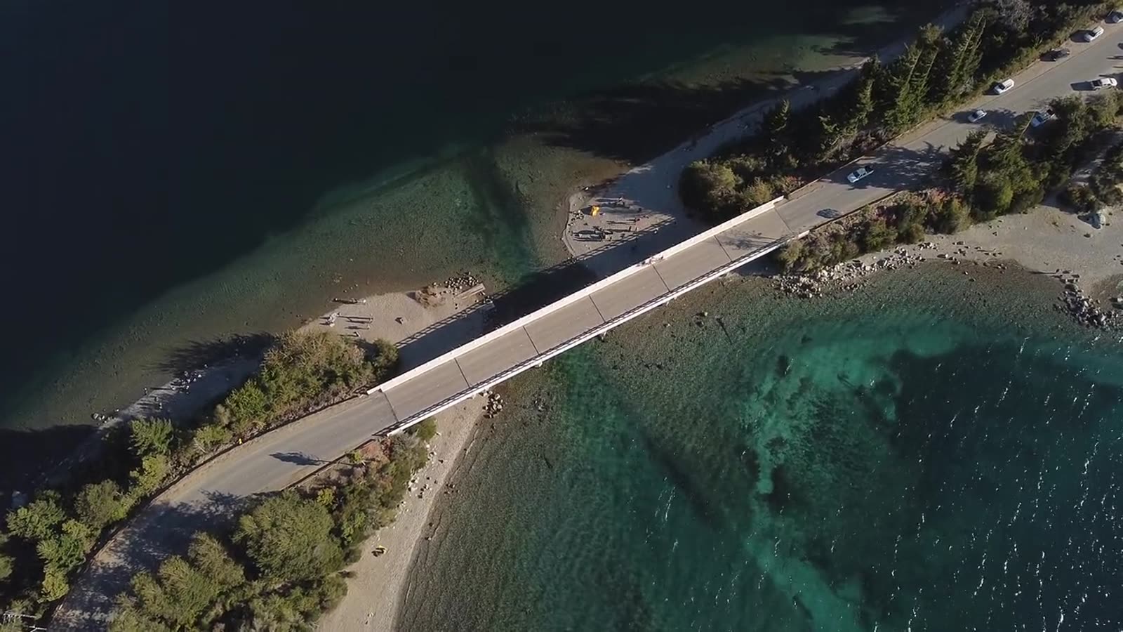 Vista aérea de un puente sobre el lago con autos circulando